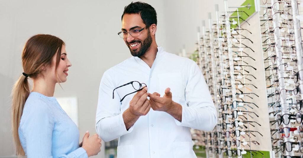 Woman picking out glasses with Optometrist 