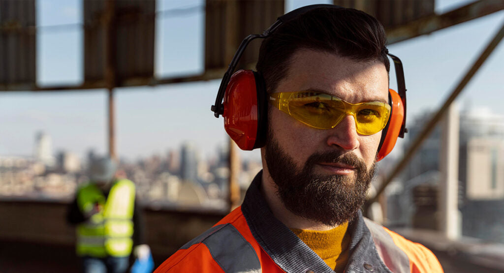 Man at construction site wearing safety glasses 
