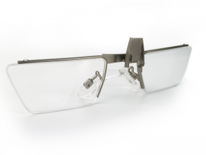 Rectangular-shaped stem-less clip-on eye glasses with metal bridge and nose piece. A metal piece sticks out over the left lens to clip onto a HoloLens device.