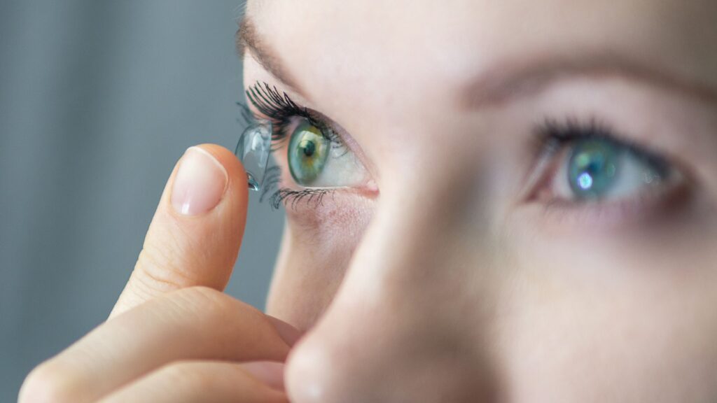 woman puts in a contact lens